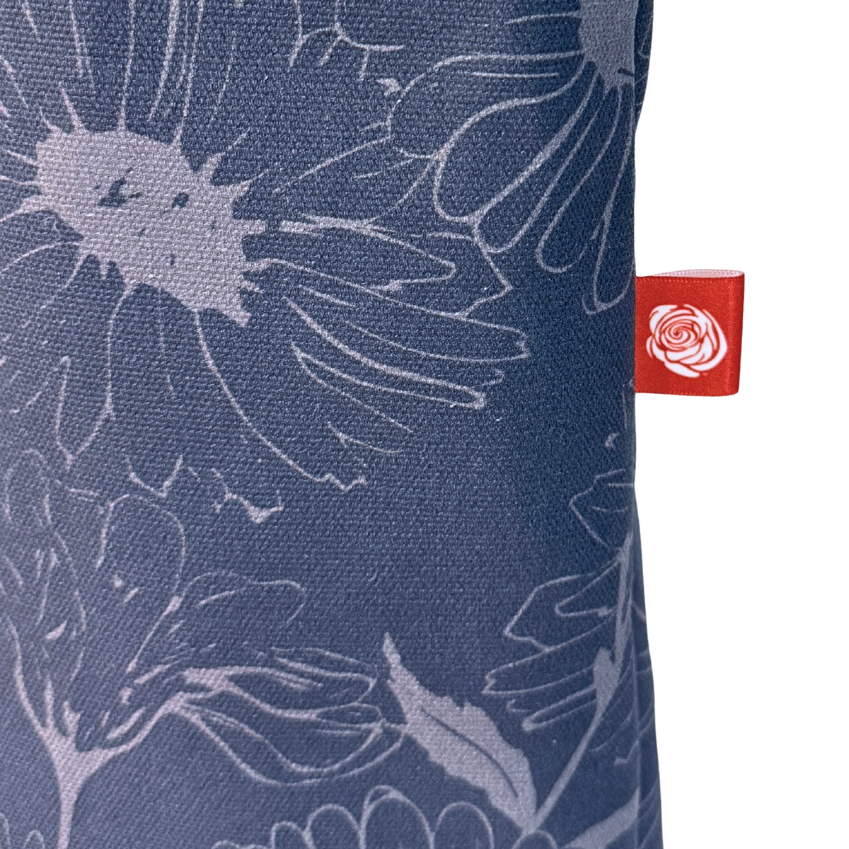 Gaia Shoulder Carry Tote in Wild Daisy, Twilight, closeup view of logo tag