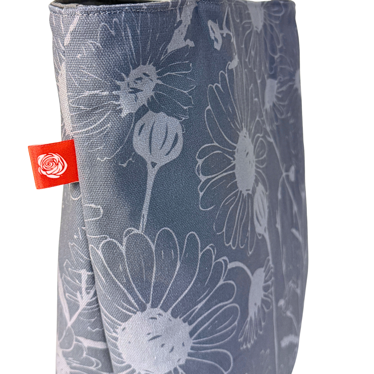 Gaia Shoulder Carry Tote in Wild Daisy, Harbor Mist, closeup view of logo tag