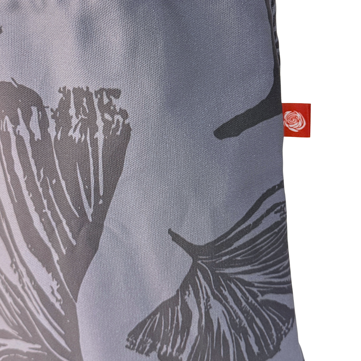 Gaia Shoulder Carry Tote in Evening Ginkgo, closeup view of logo tag