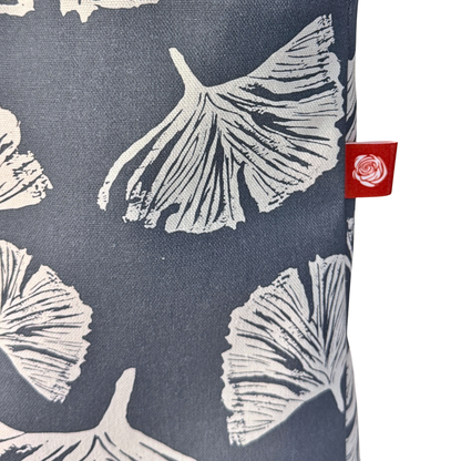 Gaia Shoulder Carry Tote in Ginkgo Poppy, closeup view of logo tag