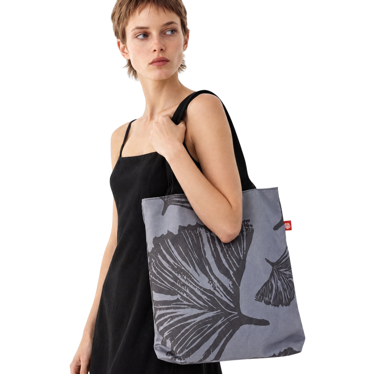Gaia Shoulder Carry Tote in Evening Ginkgo, model in black dress carrying tote on shoulder
