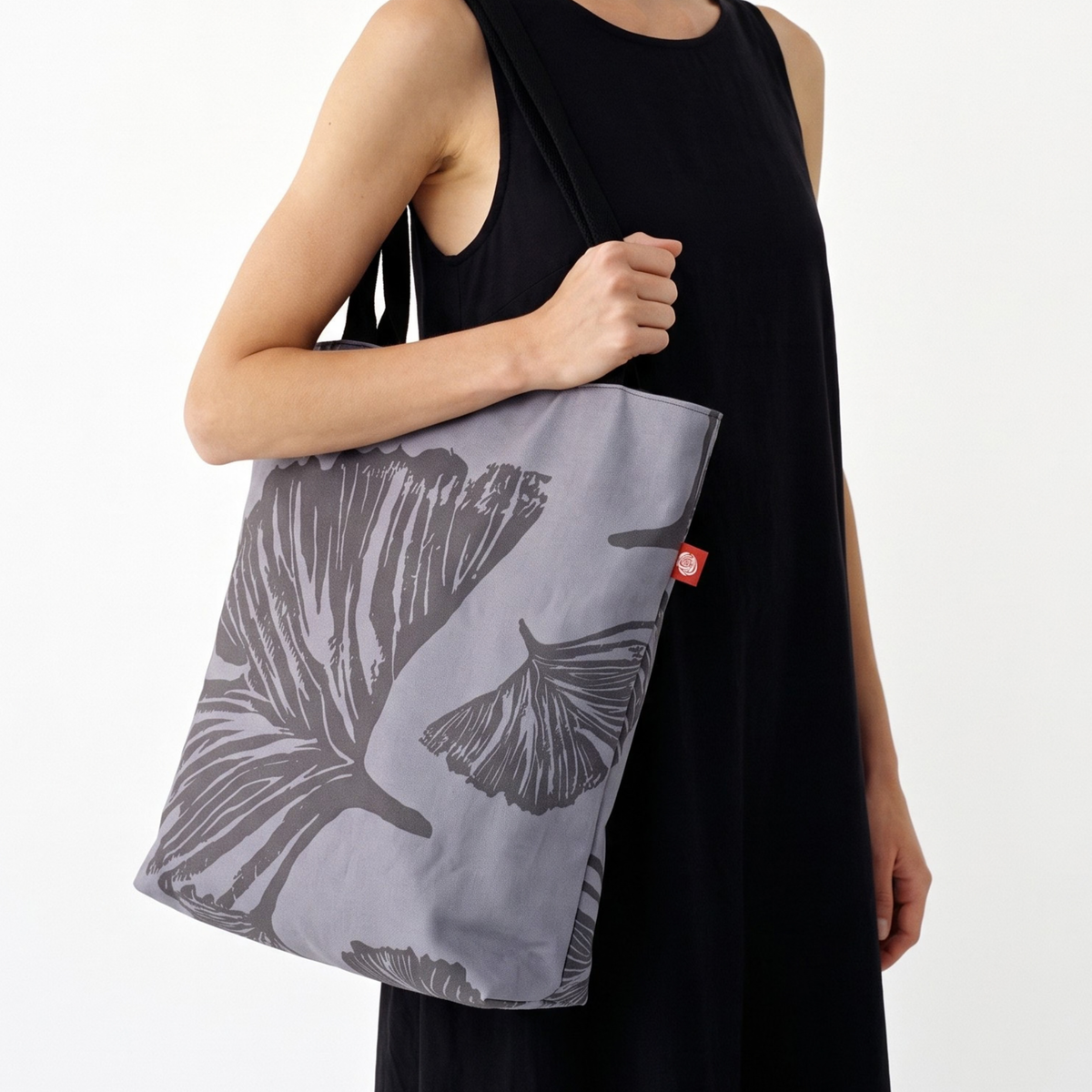 Gaia Shoulder Carry Tote in Evening Ginkgo, closeup view of model in black dress carrying tote on shoulder