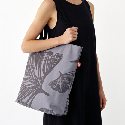 Gaia Shoulder Carry Tote in Evening Ginkgo, closeup view of model in black dress carrying tote on shoulder
